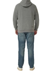 Grauer Hoodie mit Kapuze, Rückansicht, kombiniert mit hellblauen Jeans. Das Sweatshirt verfügt über einen gerippten Saum und Ärmelbündchen sowie ein dezentes Branding am unteren Rand.