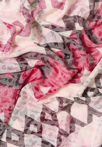 Tessuto trasparente con un motivo astratto in sfumature di rosa, rosso e grigio, caratterizzato da una texture morbida e una caduta fluida.