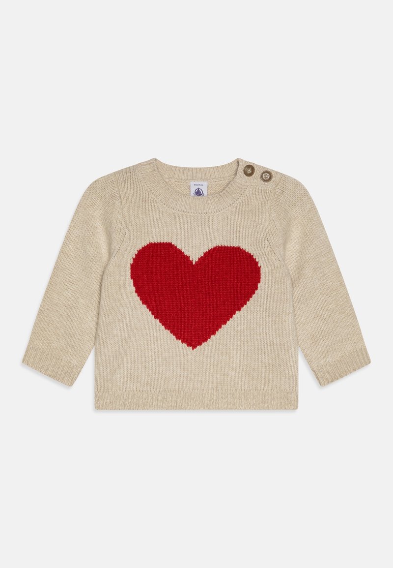 Pull en maille beige avec un grand design de cœur rouge sur le devant. Comprend des boutons à l'épaule pour un enfilage facile. Manches longues, poignets côtelés.