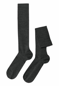 Calze grigio scuro a ginocchio realizzate in un materiale morbido e strutturato. Presentano un design a maglia liscia e punte rinforzate. Una calza è arrotolata.
