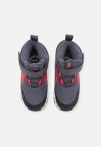 Zapatos infantiles grises y rojos con interior acolchado, correa de velcro, suela de goma y acentos texturizados. Diseño ligero de media caña.