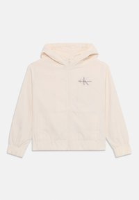 Lys kremfarget zip-jakke med hette, elastiske ermer og sidelommer. Har "Calvin Klein Jeans"-logo i grått på brystet.