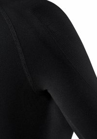 Vêtement noir à manches longues en matériau doux et extensible. Présente des accents texturés sur les épaules et une finition de couture lisse.