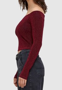 Burgundy off-the-shoulder pitkähihaiset paita, valmistettu kimaltelevasta materiaalista, muotoiltu malli, lyhyt pituus, ribatut hihansuut ja hienovarainen kiilto.