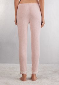 Roze katoenen legging met een zachte textuur, aansluitend ontwerp en decoratieve kantafwerking aan de onderkant. Glad afwerking en enkel-lange snit.