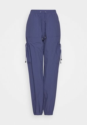 Pantalones cargo azul oscuro con cintura elástica y puños en los tobillos, bolsillos delanteros de parche y detalles con cordón en los laterales y la cintura.