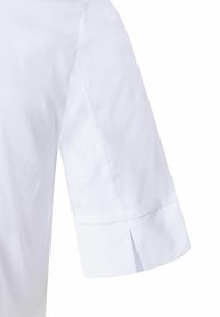 White short-sleeve shirt featuring a cuffed design, smooth cotton fabric, and a subtle split at the cuff for added detail.