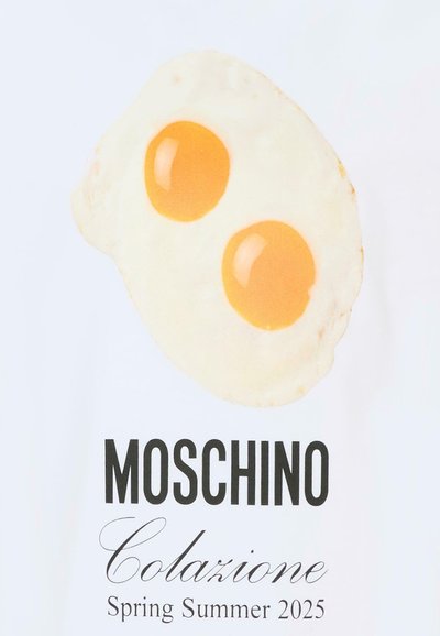 Due uova fritte sopra la scritta in grassetto "MOSCHINO," in corsivo "Colazione," e il testo "Primavera Estate 2025" su uno sfondo bianco.