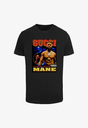 Čierne bavlnené tričko s grafickou potlačou dvoch postáv, výrazným textom "GUCCi" a "MANE" v žltej a červenej farbe na farebnom pozadí.