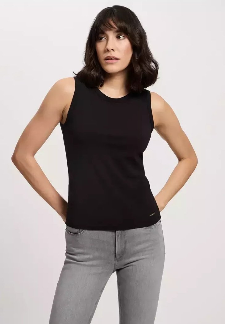 Czarny bezrękawnik o dopasowanym kroju, okrągłym dekolcie i gładkiej teksturze. W połączeniu z jasnoszarymi dżinsami. Złoty detal z logo na dole.