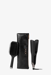 Pochette noire texturée à motif crocodile avec quincaillerie en or rose, brosse à cheveux noire et lisseur à cheveux noir et élégant.