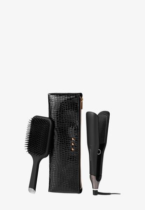 Zwarte, gestructureerde pouch met krokodilpatroon en roségouden accenten, een zwarte haarborstel en een zwarte, slanke haarstylers.