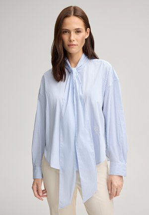 Helles blau-weiß gestreiftes Blusenshirt mit einem Kragenbanddetail, langen Ärmeln und einem gestickten Logo. Aus glattem Stoff gefertigt.