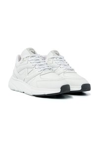 Weiße Sneakers mit einem glatten Lederoberteil, Mesh-Akzenten, gepolstertem Kragen und grauer Gummisohle. Mit Schnürsenkeln und Logo auf der Zunge.