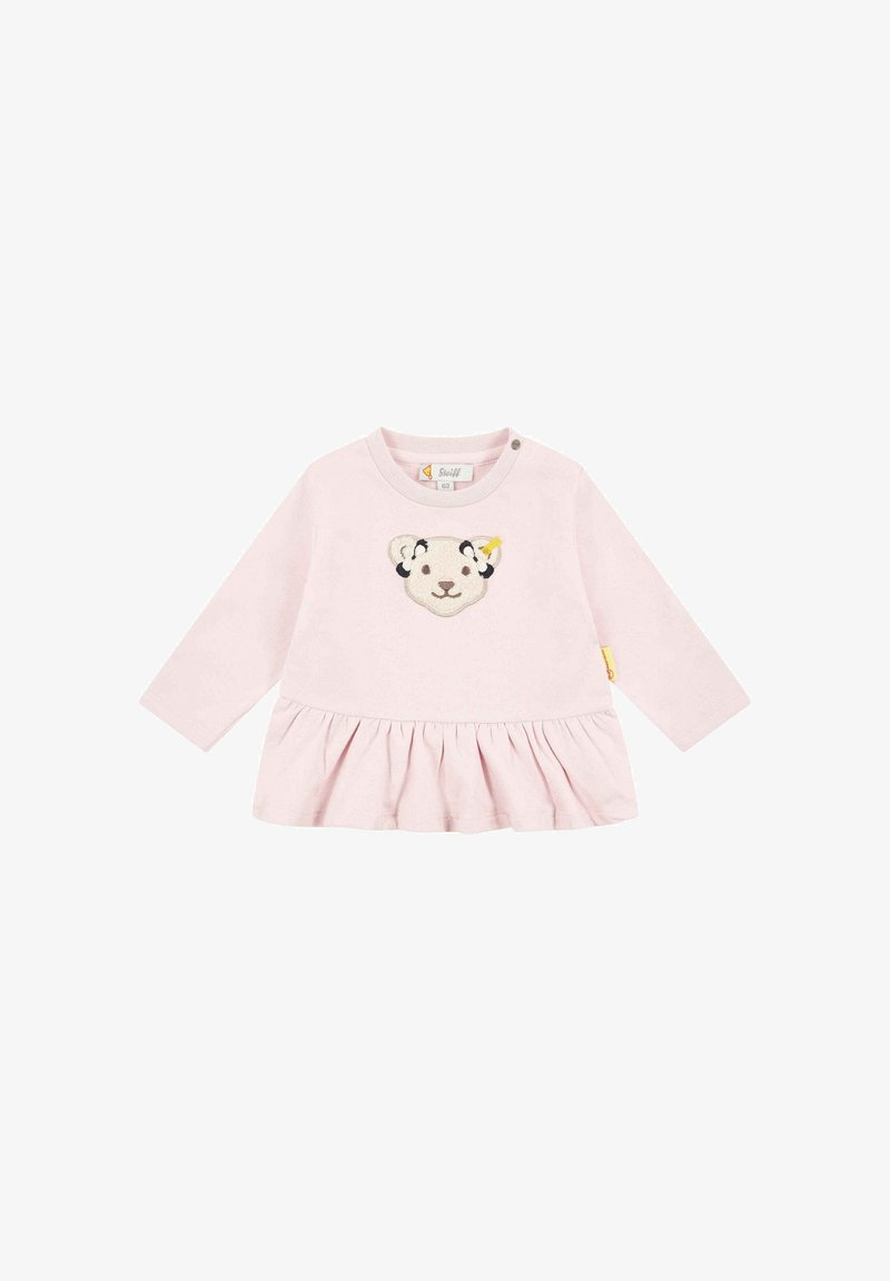 Vestido largo de manga larga color rosa con dobladillo fruncido, que presenta un diseño de cara de león cosido en el pecho y detalle de botones a presión en el hombro.