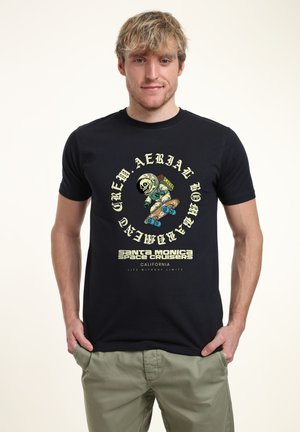 Černé bavlněné tričko s grafickým designem zobrazujícím bruslařského astronauta, textem "Santa Monica Space Cruisers" a vintage style písmem.