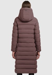 Lang, puffy, mauve frakke med hætte og horisontal quiltet mønster, der har en høj krave og diskret branding på bagsiden.