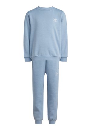 Sweatshirt bleu clair et joggings assortis en coton doux, avec le logo blanc Adidas sur le haut et le bas. Poignets et taille côtelés.