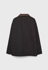 Zwarte jas met een corduroy kraag, lange mouwen en een rechte snit. Beschikt over een naad over de rug en twee metalen drukknoopjes aan de zoom.