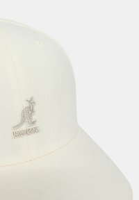 Cappellino da baseball bianco realizzato in tessuto testurizzato, con logo di un canguro ricamato in argento sul pannello frontale.