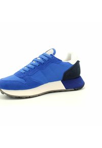 Blauer Sportschuh mit einer Kombination aus glattem Stoff und Wildledertexturen, einem weißen Kragen und einem kontrastierenden dunkelblauen Fersenbereich.