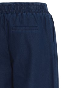 Pantalon bleu marine avec taille élastique et une seule poche passepoilée au dos côté droit.