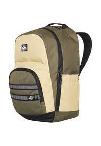 Two-tone olive green and beige backpack with front zippered pocket, side pocket, black straps, and Quiksilver logo on front panel.