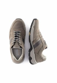 Graue Sportschuhe mit einem Obermaterial aus Wildleder und Mesh, ausgestattet mit zwei dunkelgrauen Streifen, Schnürverschluss und einer dicken schwarzen Gummisohle.