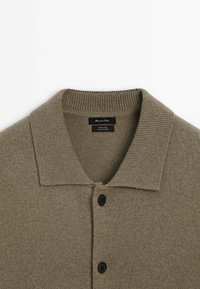 Cardigan en laine brune avec col côtelé et deux boutons noirs, étiquette indiquant 100 % laine, fabriqué en Chine par Massimo Dutti.