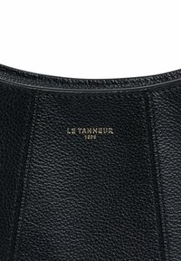 Borsa a mano in pelle nera con finitura testurizzata, logo del marchio impresso in oro e cuciture pulite lungo i bordi.