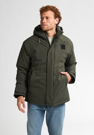 Olive green puffer jacket with a hood, front zip and button closures, side pockets, contrasting black accents, and a padded texture.