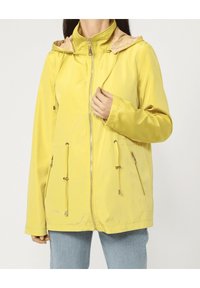 Chaqueta ligera de color amarillo brillante con cierre de cremallera, capucha ajustable y forro con estampado rosa. Cuenta con dos bolsillos frontales y un corte relajado.