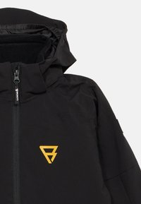Czarna kurtka z kapturem, zapinana na zamek z przodu, z żółtym trójkątnym logo na piersi, na białym tle.