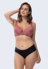 Wireless bra in soft rose color with lace accents, smooth cups, and adjustable straps; paired with black seamless hipster underwear.
