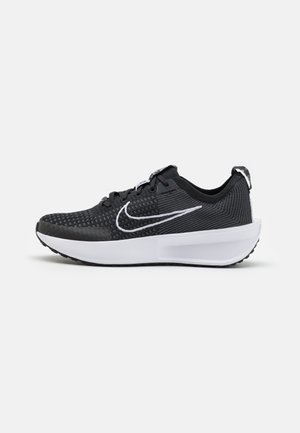 Black athletic shoe with a textured mesh upper, white accents, and a cushioned white sole; features a lace-up design and padded collar.