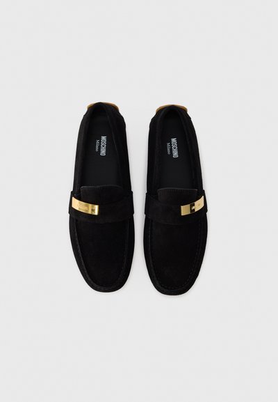 Svarta mockaloafers med en guldmetalldetalj över vampen och en sydd profil. Skor med slip-on design, en strukturerad yttermaterial och en slät foder.