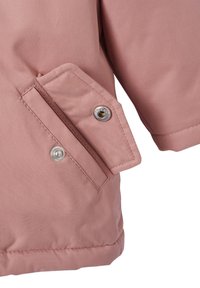 Close-up of dusty pink jacket pocket with flap secured by silver snap button, showing part of sleeve and hem stitching.