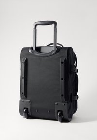 Black wheeled suitcase made of durable fabric with a retractable handle, textured sides, and reinforced corners. Features inline skate wheels.