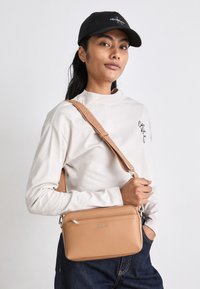 Calvin Klein MUST CONVERTIBLE CAMERA BAG - Borsa a mano - lion
