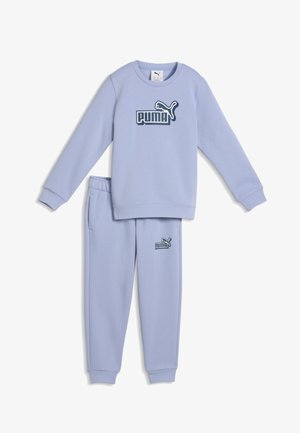 Jasnofioletowy dres Puma z bluzą z długim rękawem i pasującymi spodenkami dresowymi, oba z logo Puma w ciemnym niebieskim kolorze.