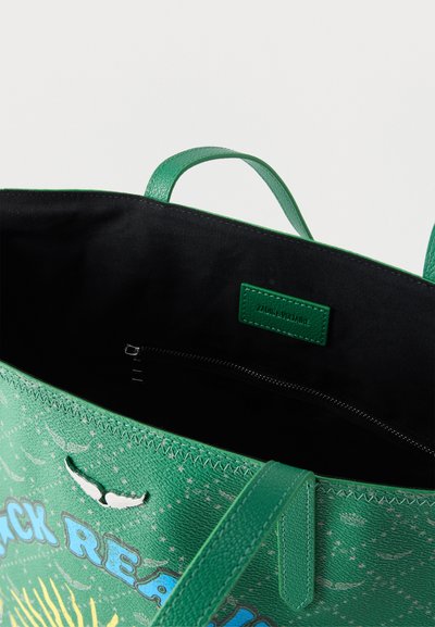 Πράσινη τσάντα tote με μπλε και κίτρινο γραφικό κείμενο, μαύρο υφασμάτινο εσωτερικό, τσέπη με φερμουάρ και πράσινες λαβές.