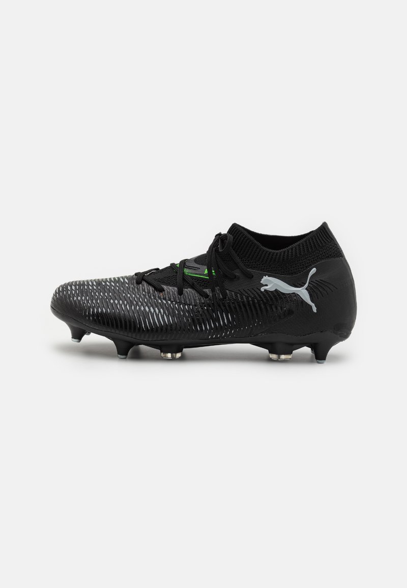 Botas de fútbol negras con parte superior texturizada, cuello de calcetín tejido, acentos verdes y logo plateado. Presenta tacos cónicos para tracción.