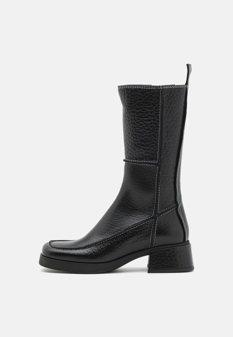 Black leather ankle boot with textured finish, block heel, contrast white stitching, and a rounded toe. Side pull-tab for easy wear.