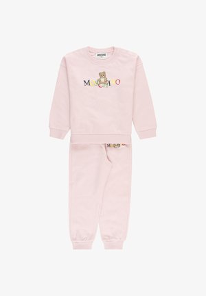 Set di felpa e pantaloni per bambino di colore rosa chiaro con polsini a coste, con un orsetto e il colorato logo "Moschino" sul davanti.