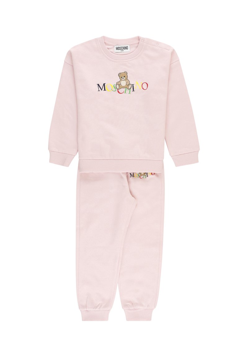 Set di felpa e pantaloni per bambino di colore rosa chiaro con polsini a coste, con un orsetto e il colorato logo "Moschino" sul davanti.