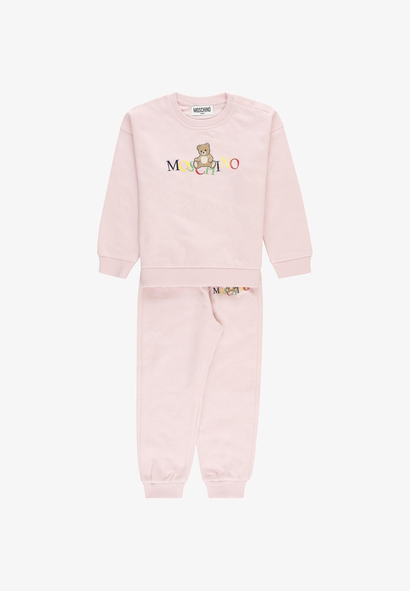 Set di felpa e pantaloni per bambino di colore rosa chiaro con polsini a coste, con un orsetto e il colorato logo "Moschino" sul davanti.