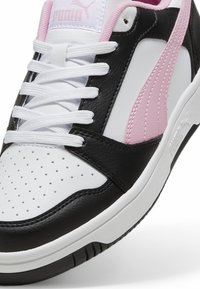 Puma sneakers med en sort, hvid og pink farveskema. Glat læderoverdel, perforeret tå og hvide snørebånd med en gummisål.