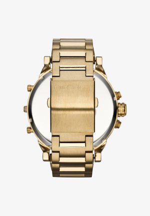 Montre-bracelet Diesel en métal doré montrant la boucle arrière et le bracelet avec des boutons latéraux visibles et une couronne sur fond blanc.
