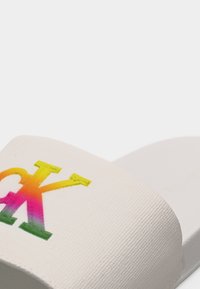 Λευκό σανδάλι με φάσα με υφή που διαθέτει το λογότυπο Calvin Klein "CK" σε διαβάθμιση ουράνιου τόξου.