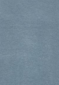 Tissu tricoté bleu au toucher lisse et à la surface uniforme. Le matériau présente de légères variations d'intensité de couleur à travers le tissu.